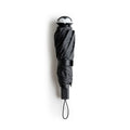 Stylish Spookula umbrella by OTOTO, features a penguin handle and wrist strap, on a white background.