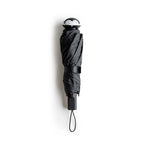 Stylish Spookula umbrella by OTOTO, features a penguin handle and wrist strap, on a white background.